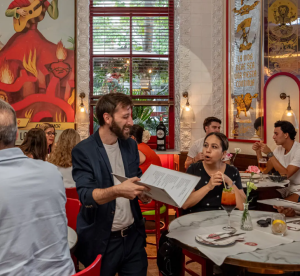 A man holds a menu in a crowded restaurant in Spain.